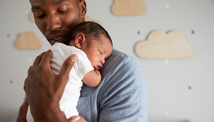 Father holding newborn baby son