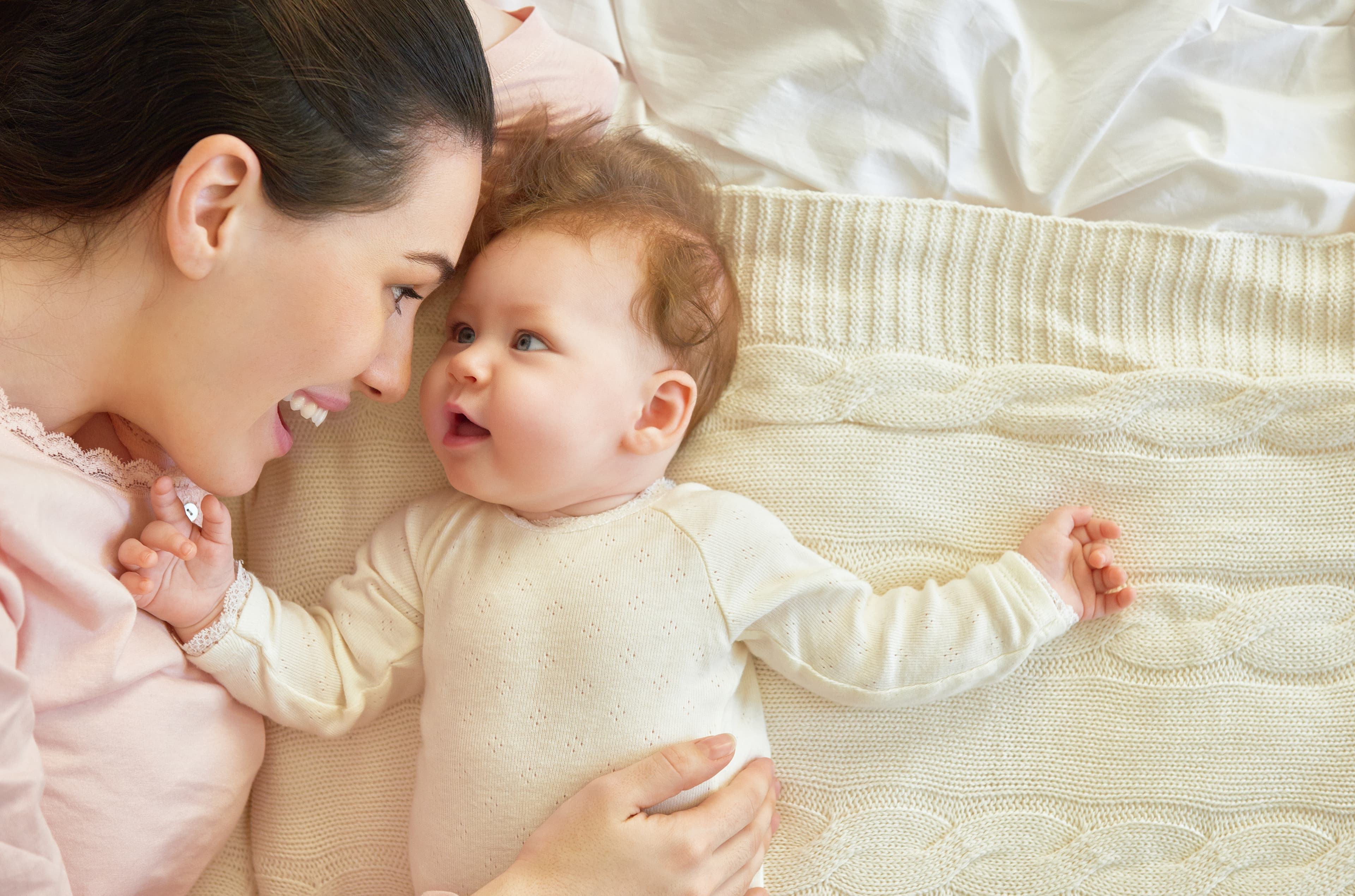 smiling baby crawling in bed