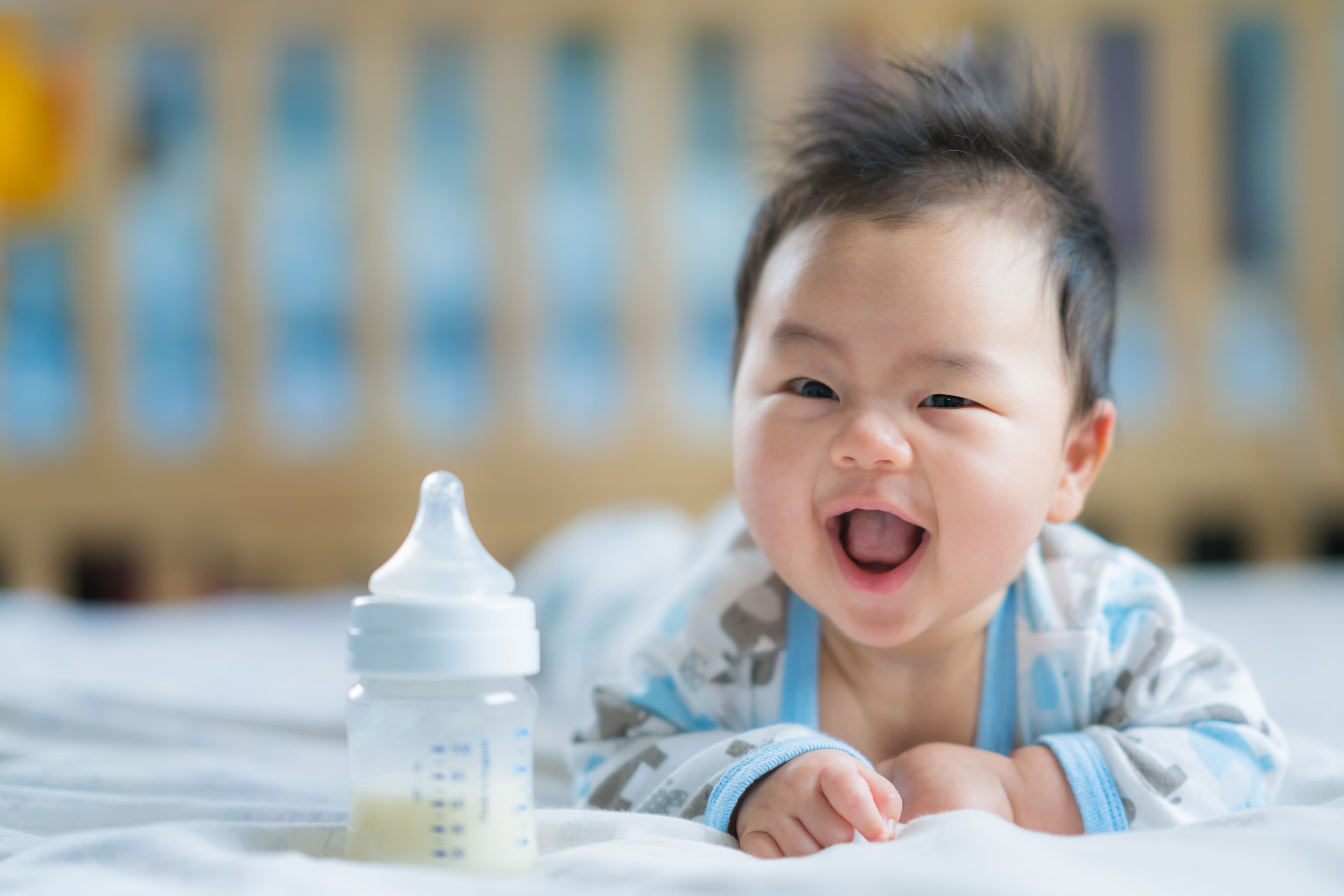 thirsty baby moving towards baby bottle