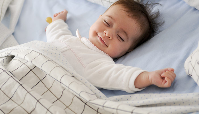 Smiling baby girl lying on bed
